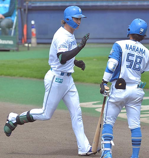 菅野から復帰後初安打となる右越え本塁打を放った浅間(左)が奈良間とタッチを交わす