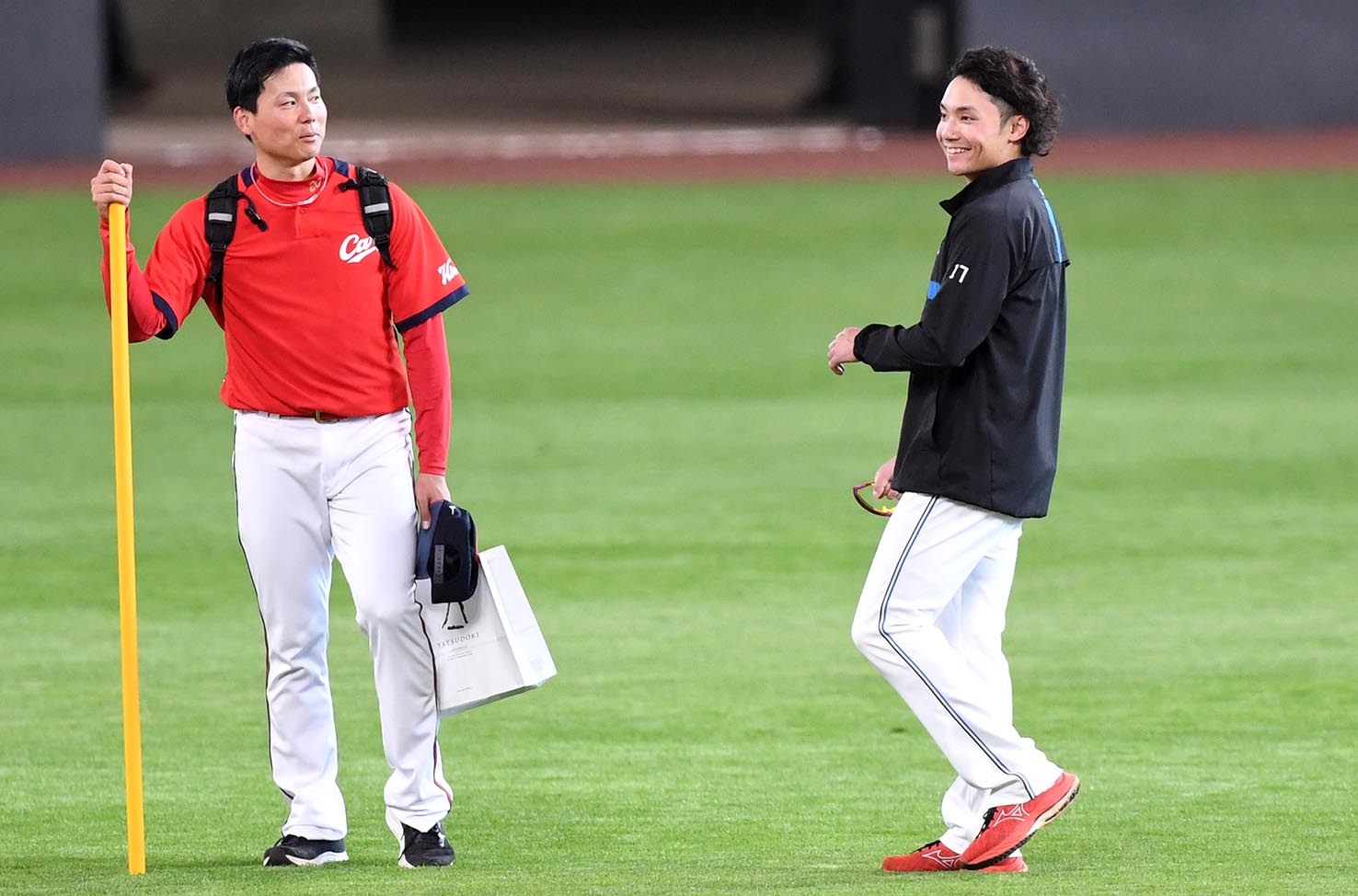 試合前練習終了後、広島・栗林（左）と談笑をする伊藤