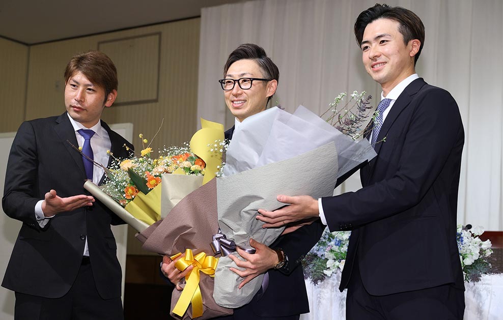 ２０２２年１２月２３日、金子コーチの引退会見で加藤貴（左）と上沢（右）が花束を渡し、記念撮影する