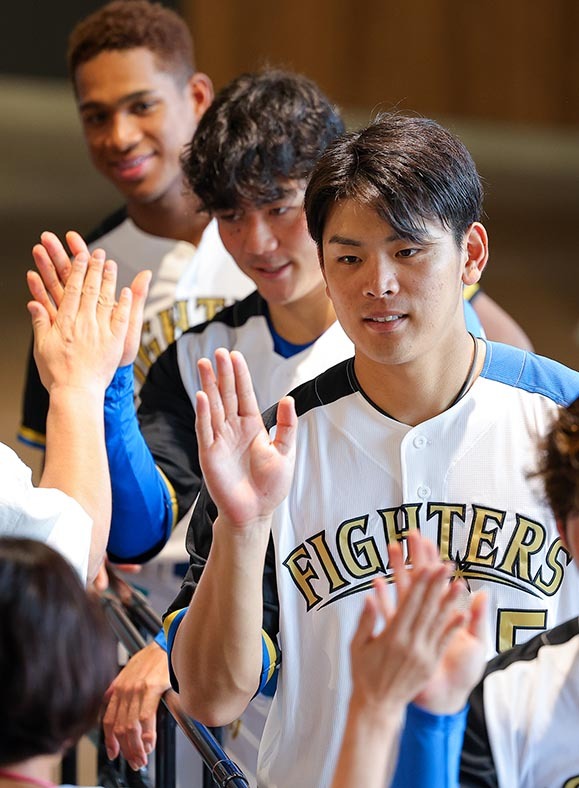 ウエルカムハイタッチでファンを迎える(手前から)野村、清宮、万波