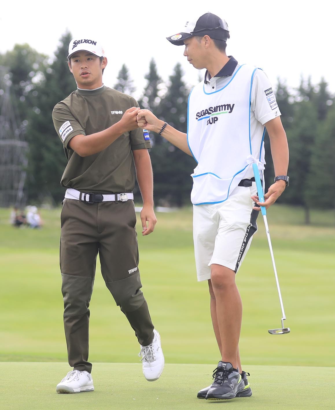 18番でイーグルを奪いキャディ(右)とグータッチする片岡