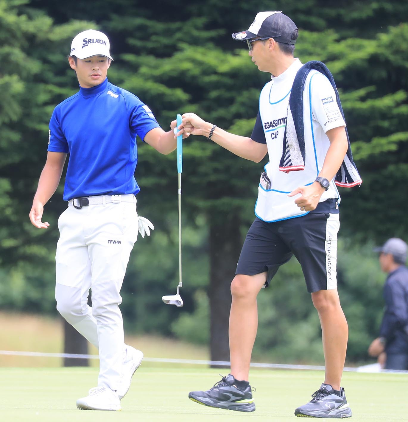 片岡(左)は首位と3打差でスタートした1番でバーディー発進。キャディーとグータッチする