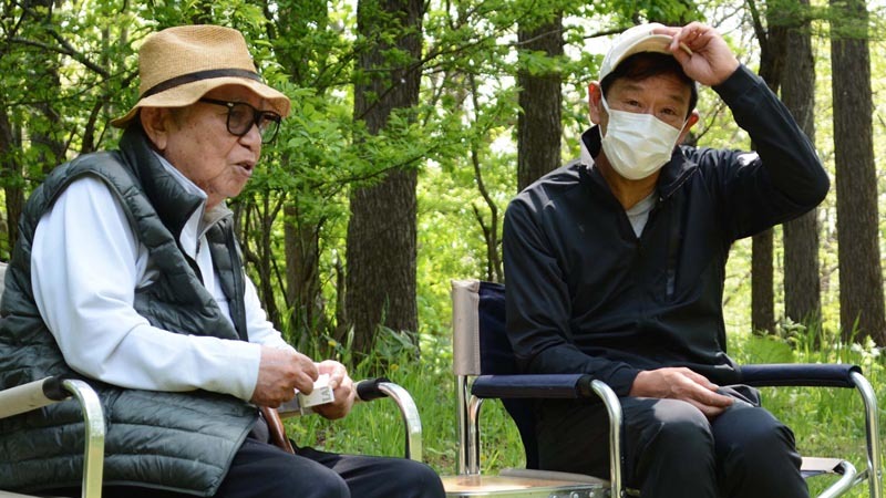 時に真剣に、時に笑顔で言葉を交わす侍ジャパンの栗山監督（右）と倉本氏