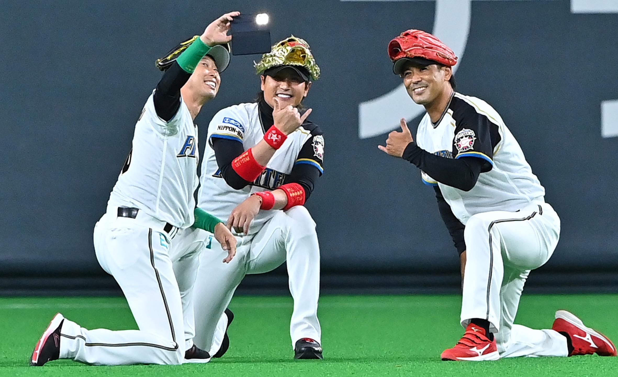 ハイ、ビッグボスポーズ♪ 試合前のセレモニーで、かつての名場面を再現し、記念写真を撮る(左から)森本氏、新庄監督、稲葉GM(撮影・桜田史宏)