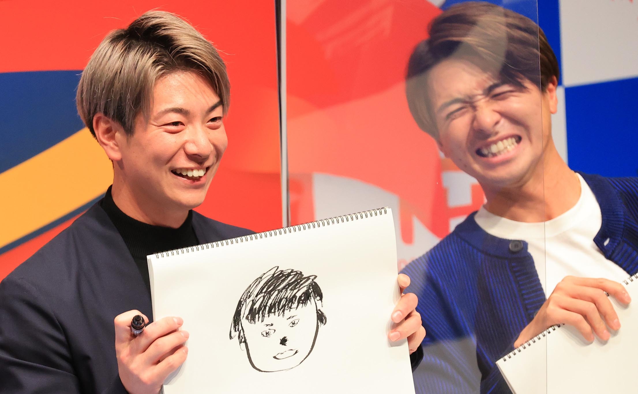 札幌でのトークショーに参加した松本剛（左）が自分で描いたまな娘の顔を披露し、画伯っぷりを発揮