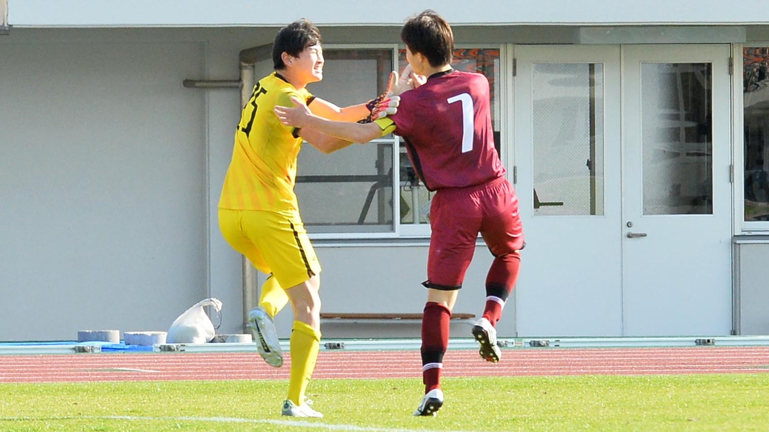 PK戦のゴールを守ったGK水口(左)と喜ぶ旭川実業主将の酒井