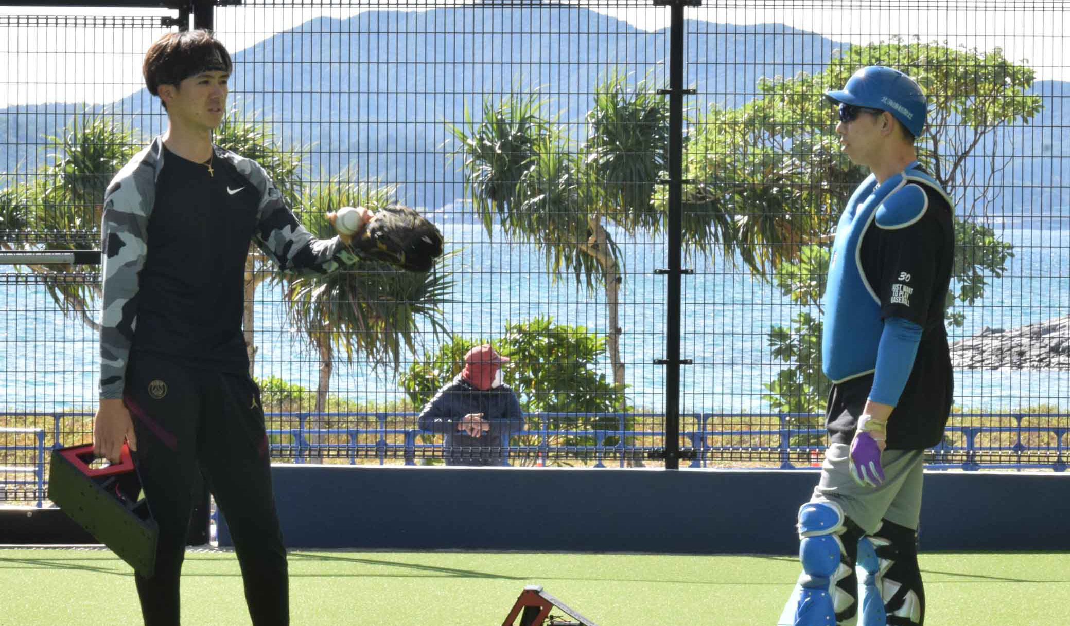 ブルペン投球を終え、上沢(左)は捕手の宇佐見と言葉を交わす(撮影・宮西雄太郎)