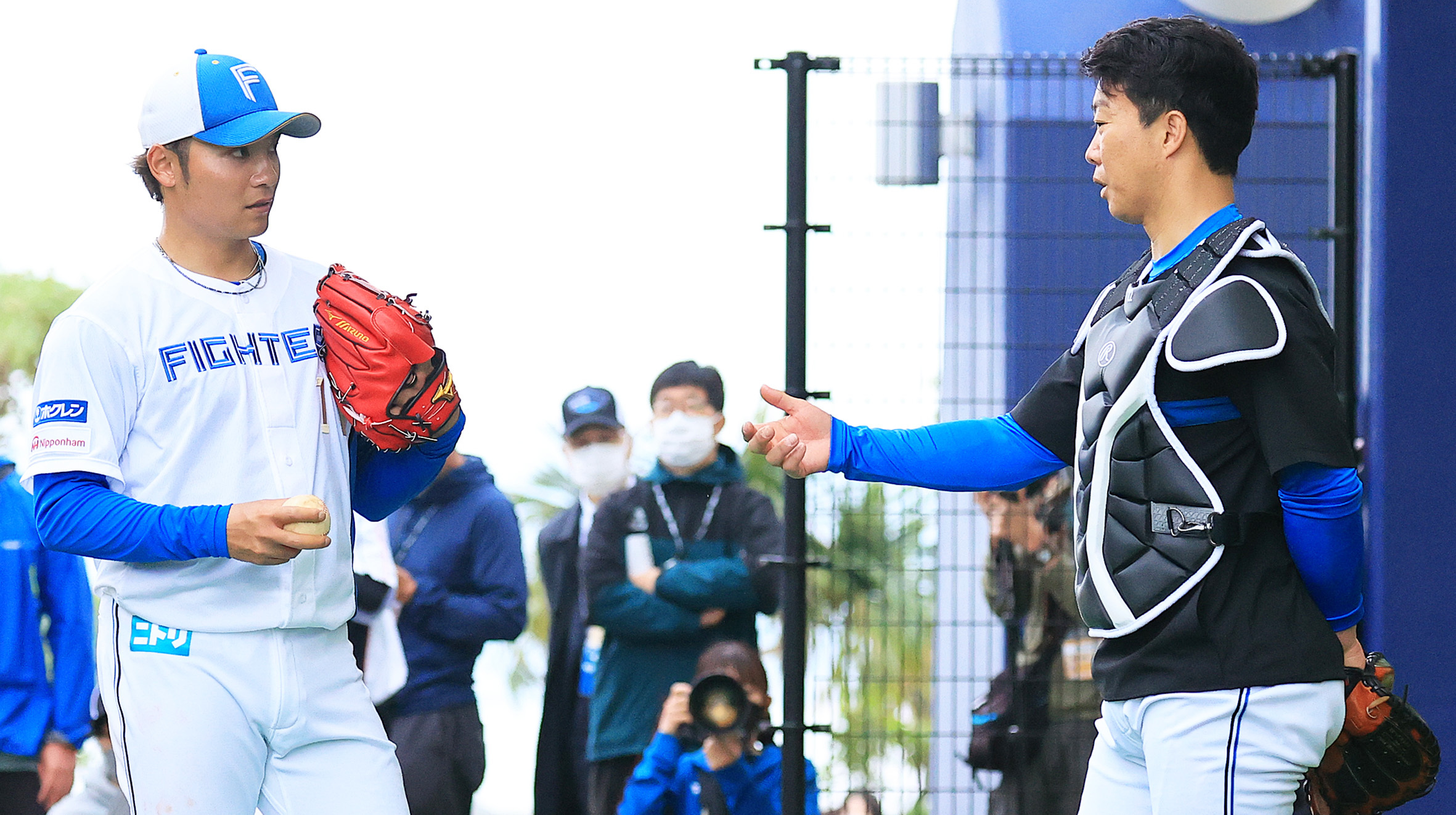 球団OBで侍ジャパンのブルペン捕手を務める鶴岡氏(右)と話し込む伊藤