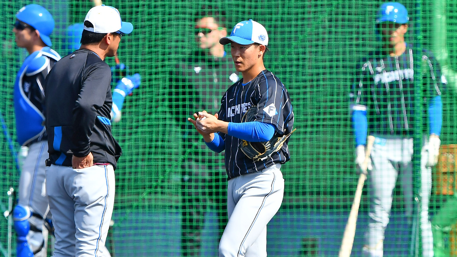 ライブBPでの投球を終え、建山コーチ(左)と話す矢沢(撮影・桜田史宏)