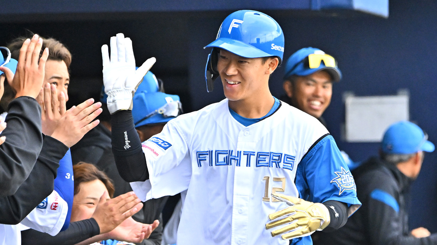 一回2死三塁、野村の適時二塁打で生還した矢沢がチームメートとハイタッチを交わす(撮影・桜田史宏)