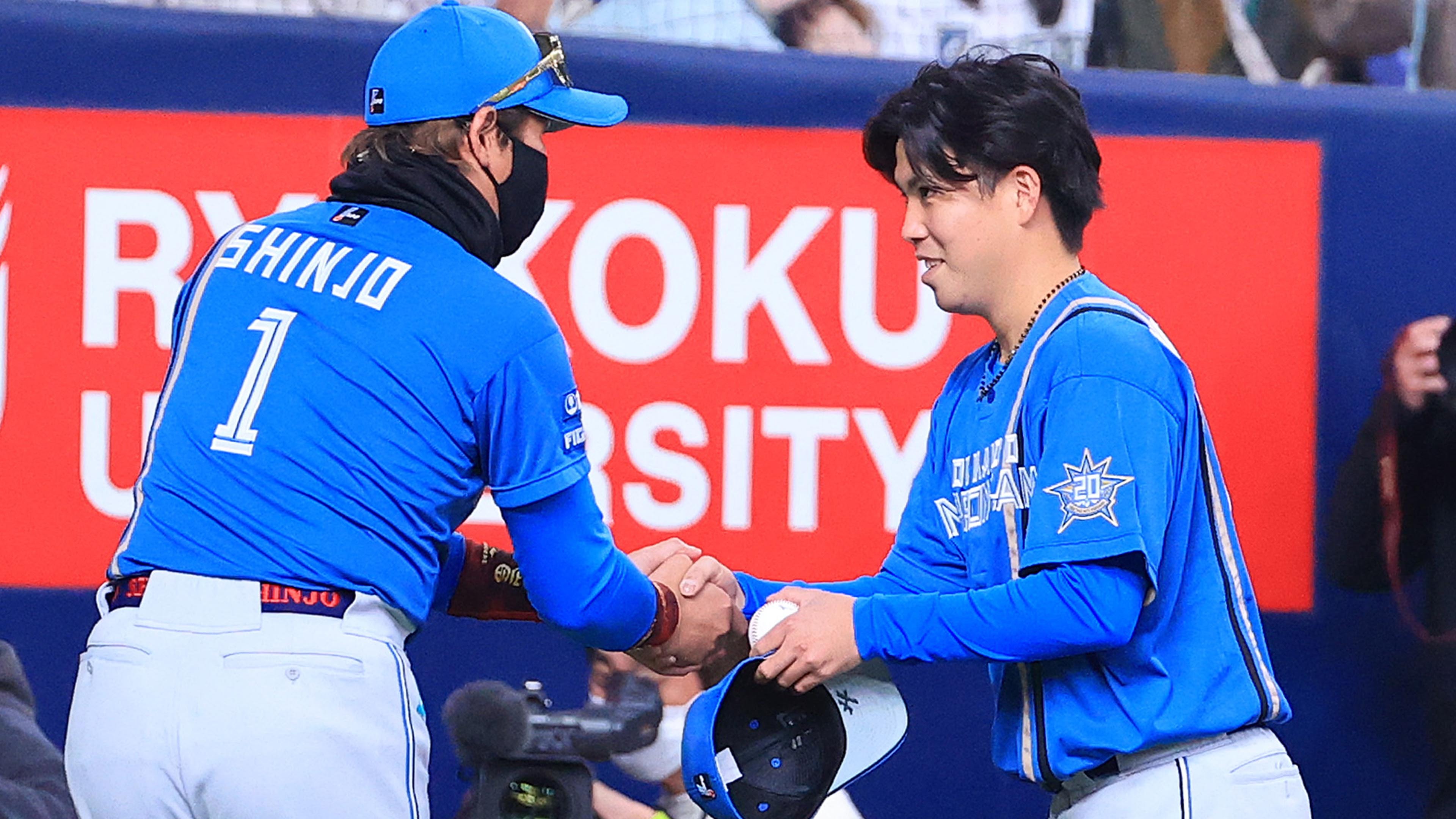 試合後、新庄監督(左)と握手を交わす金村