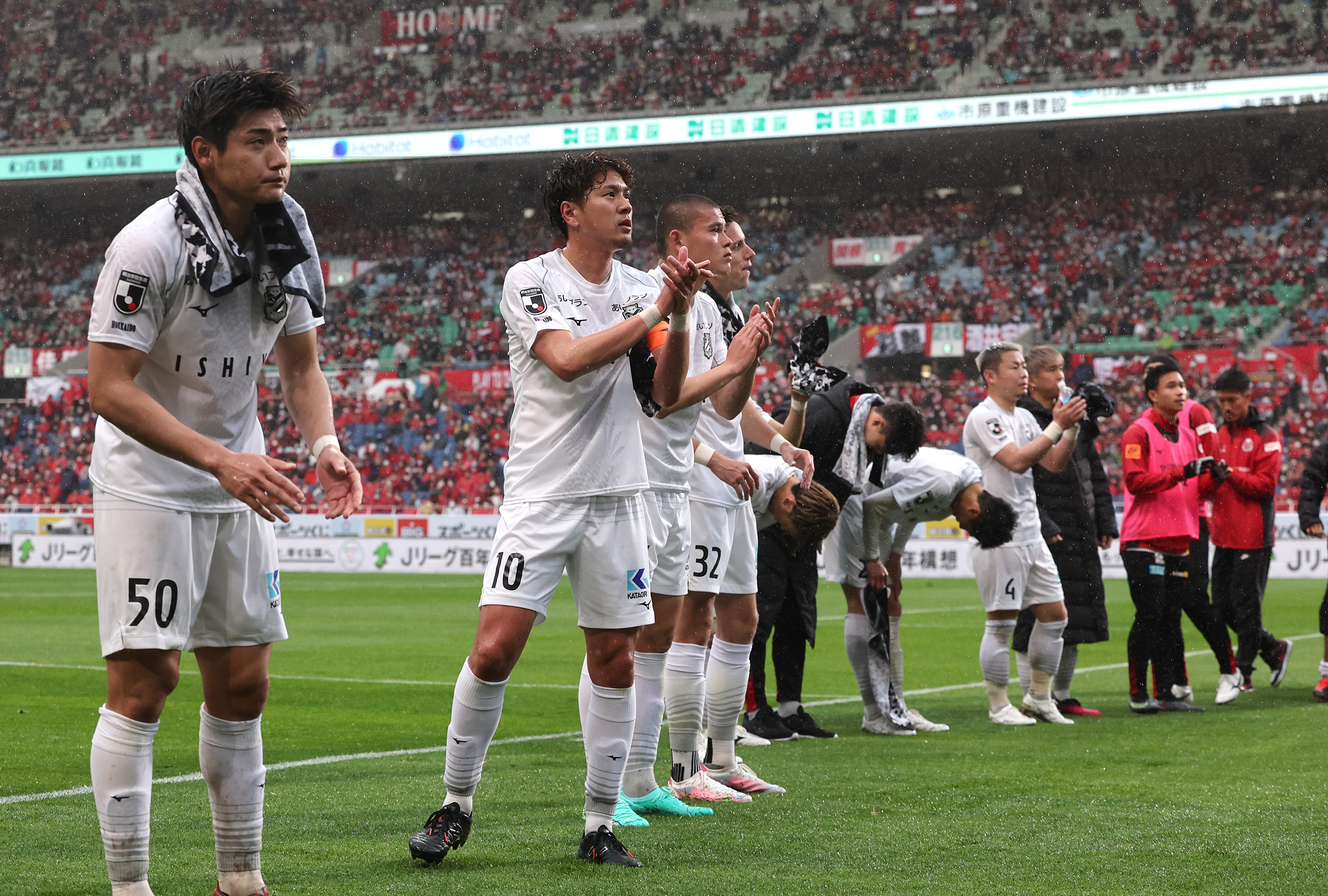 試合後、サポーターに挨拶する札幌の選手たち