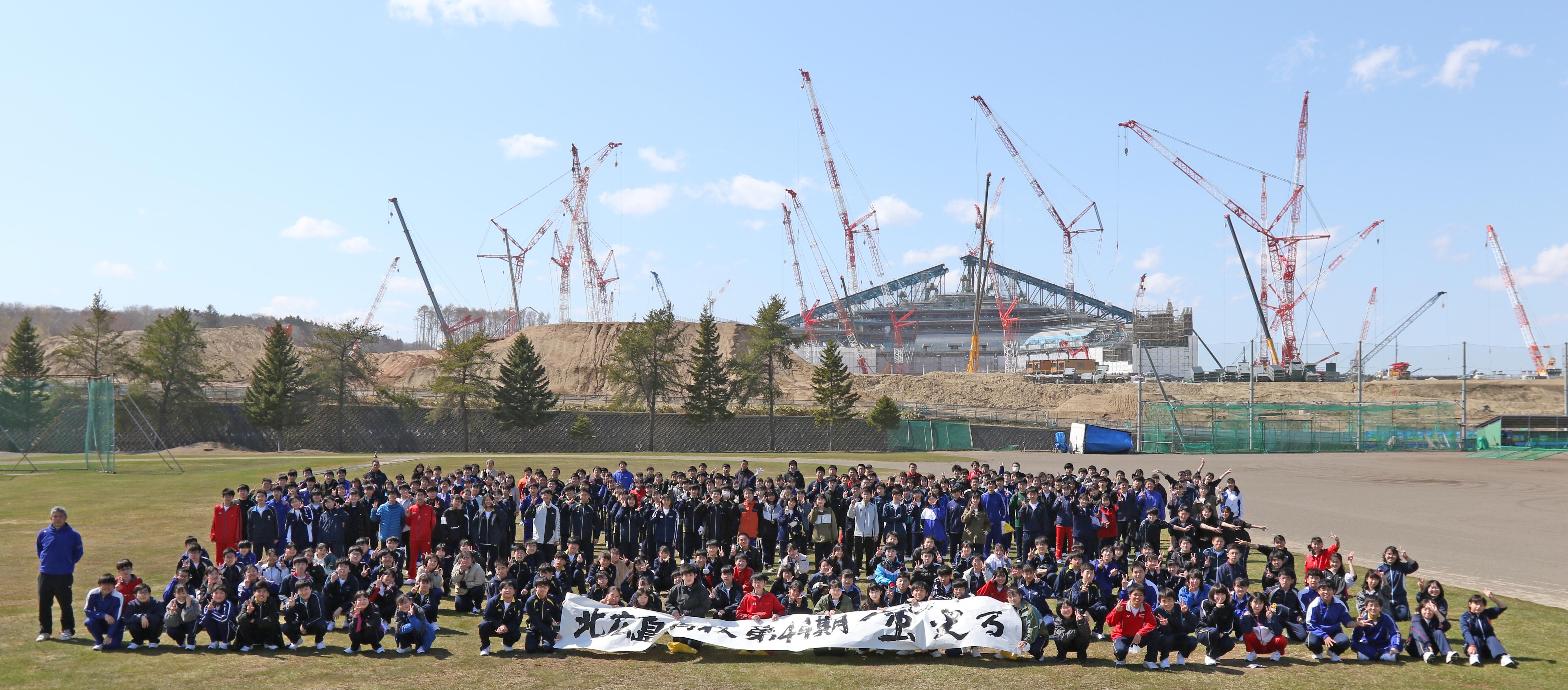 北広島高校の新入生２８０人が、新入生交流会の一環で２年後に開業するボールパークをバックに記念撮影＝２０２１年４年２１日撮影