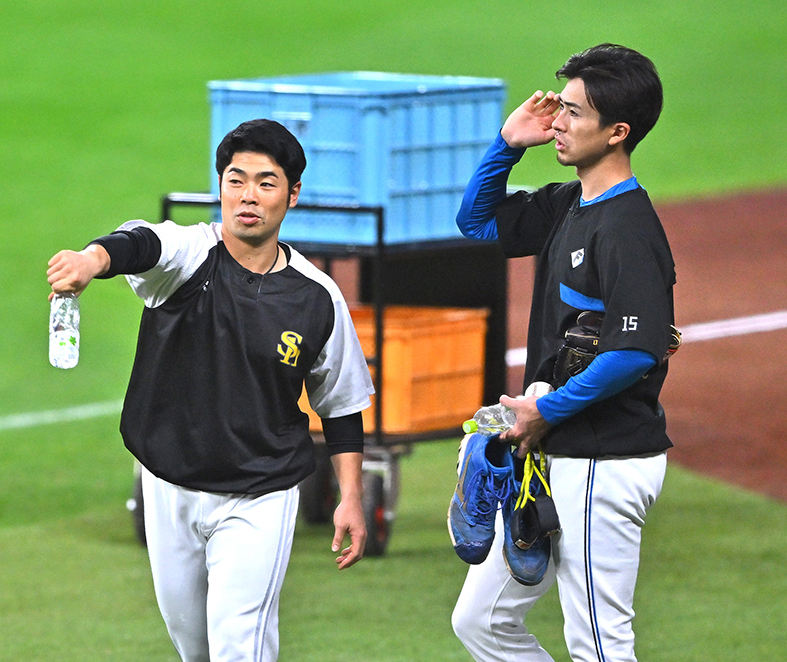 試合前練習中にソフトバンク・近藤(左)と会話する上沢
