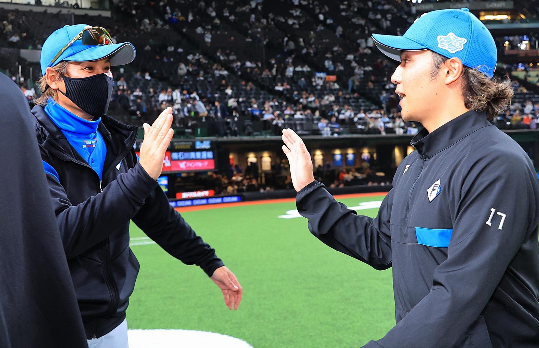 試合後、新庄監督とハイタッチを交わす伊藤(右)