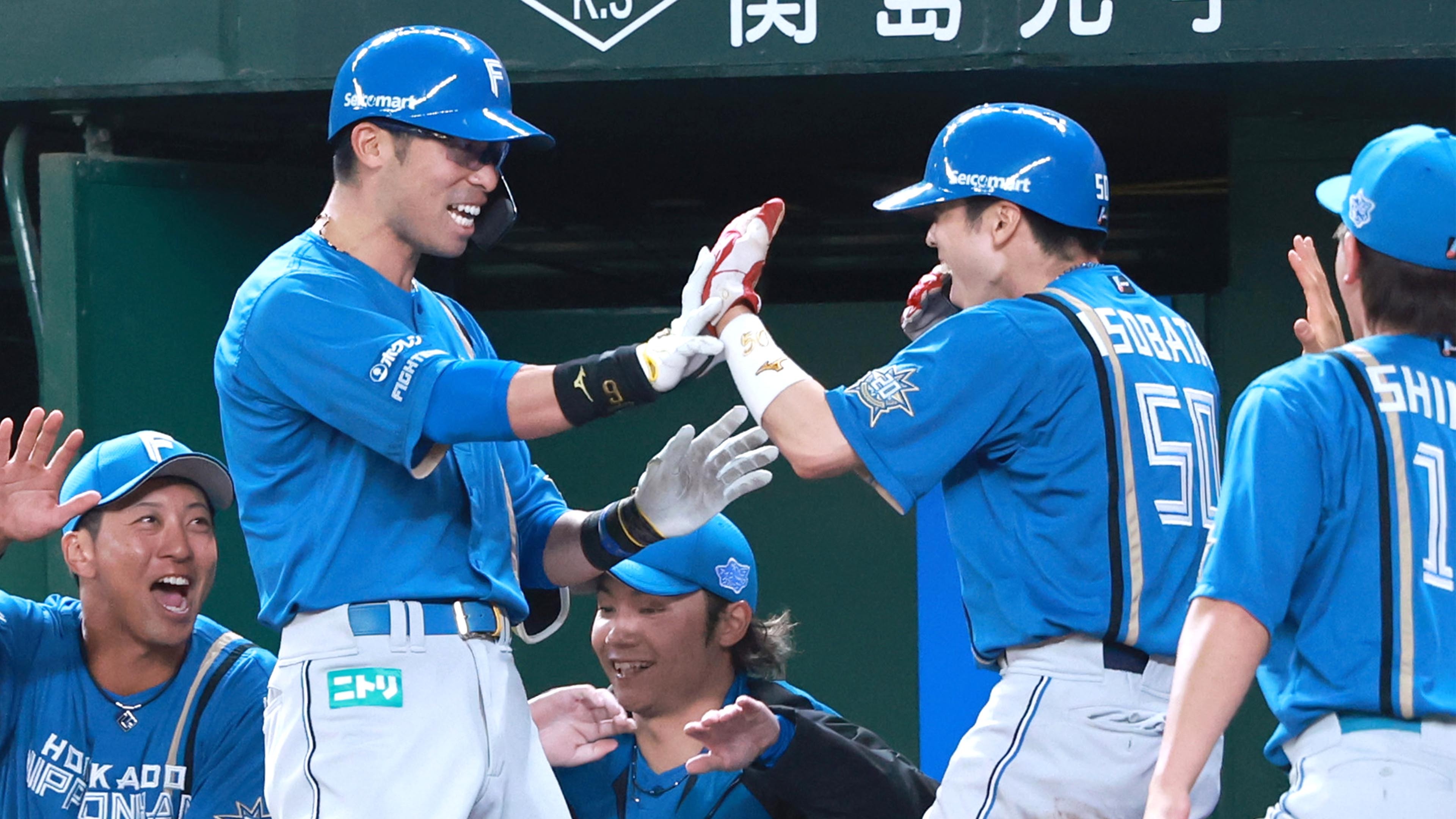 三回無死三塁、スクイズを決めた江越(左から2人目)と笑顔でタッチを交わす五十幡